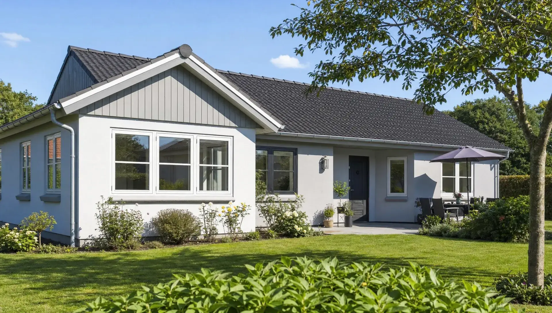 Et nymalet dansk parcelhus med frisk facade, træværk og velholdt have, der viser udendørs maling af hus i rolige omgivelser.