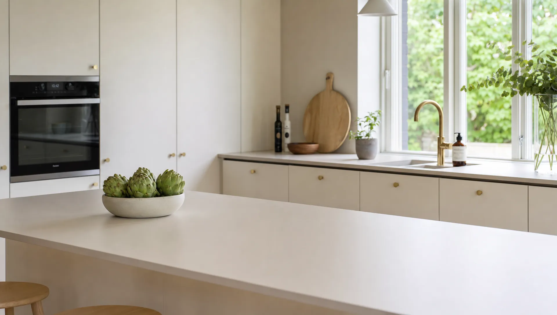 En malet køkkenbordplade med rene kanter og ensartet finish i et lyst køkken med vægge og skabe omkring den.